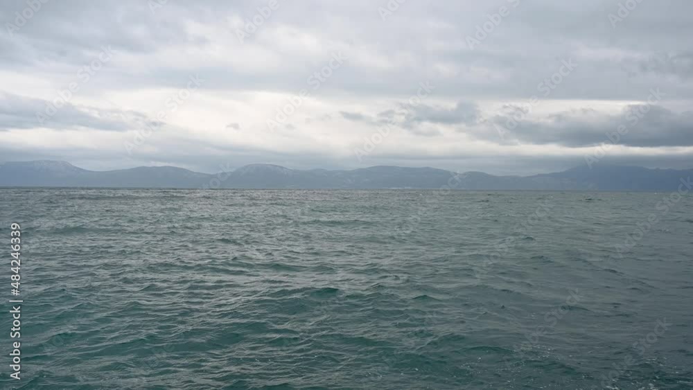 Stormy weather at the sea, view from coast. Waves on the sea with dramatic clouds above. Rainy winter day. Stormy weather at the sea, view from coast. Waves on the sea with dramatic clouds above. Rainy winter day.