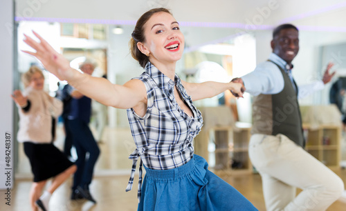 Cheerful female practicing lindy hop in pair with man photo