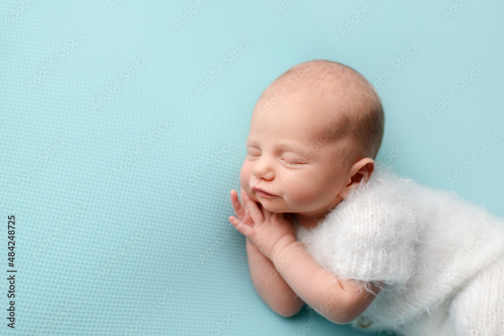 Sleeping newborn baby on a blue background. Photoshoot for the newborn. A few days from birth. Sleeping newborn baby on a blue background. Photoshoot for the newborn. A few days from birth.