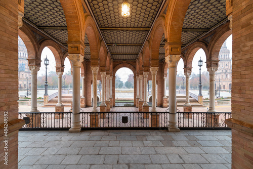 The typical columns and staircases of the famous Spanish square in Seville during a foggy morning with a view on the side towers of the monument built in 1928 for an exhibition. 