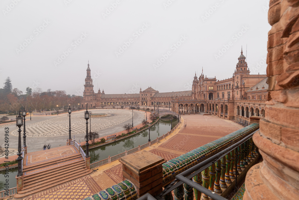 Fototapeta premium The famous Spanish square in Seville during a sunrise covered in fog. It is built in 1928 for the Ibero-American Exposition. It is a landmark with regionalism architecture and mixing elements. 