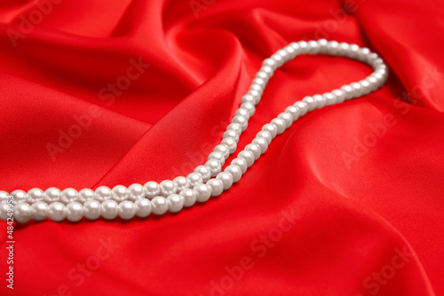 Beautiful white pearls on delicate red silk