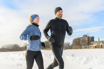 mature couple in the winter running together in nature