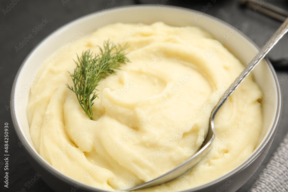 Freshly cooked homemade mashed potatoes on dark grey table, closeup