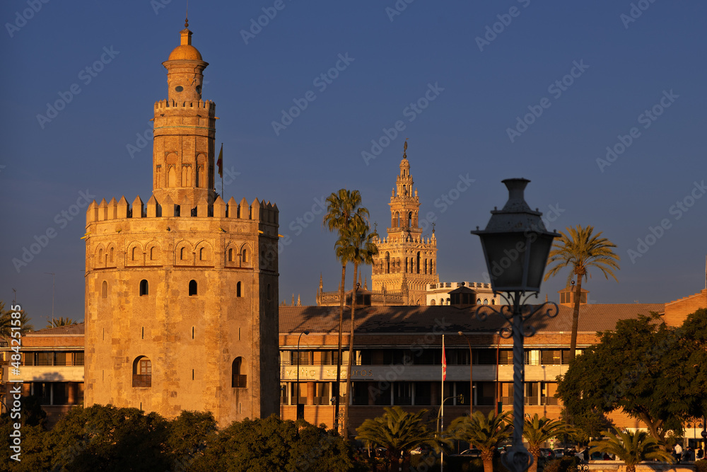 The skyline of Seville with a view on the iconic golden tower on the quayside of the rivier Guadalquivir and in the distance the Giralda tower during the golden hour