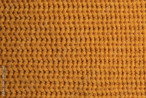 Beautiful orange knitted fabric as background, top view