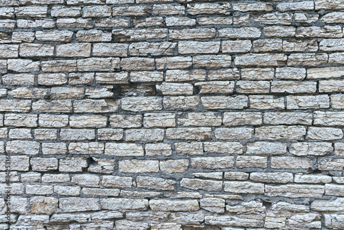 old stone wall made of weathered bricks as background