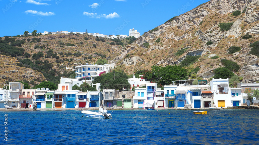 Beautiful fishermen small scenic seaside picturesque village of Klima in entrance of port of Adamantas with colourful boat houses called 