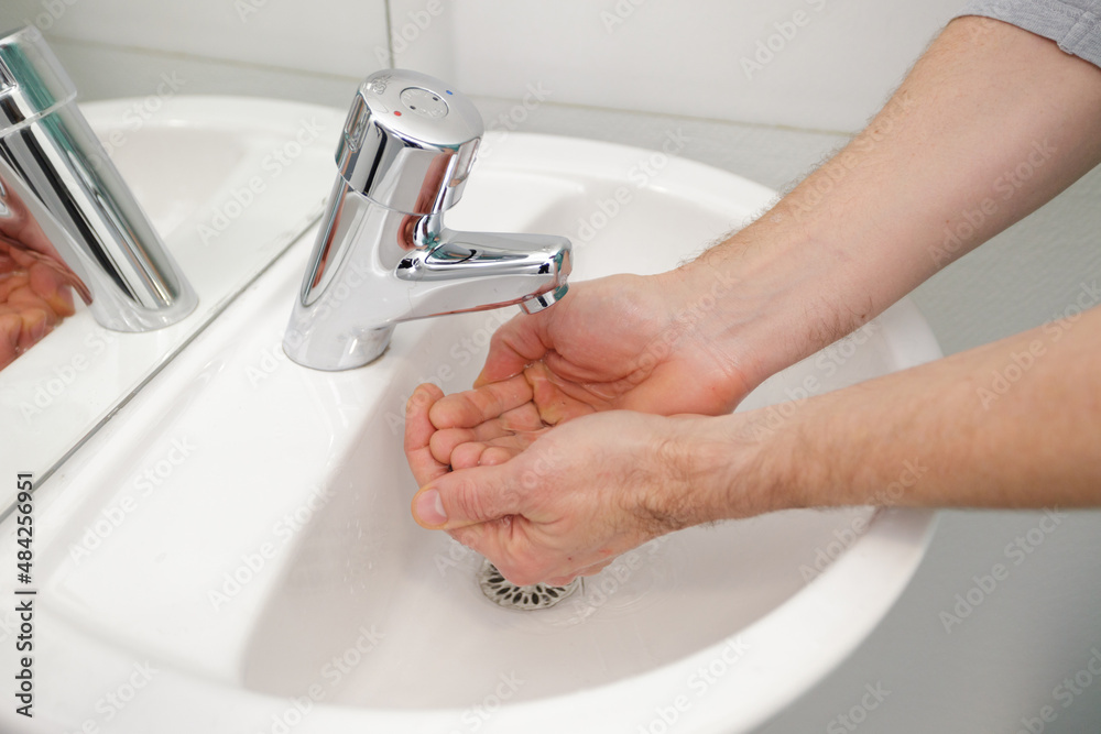 close up of man washing hands in public bathroom sink close up of man washing hands in public bathroom sink