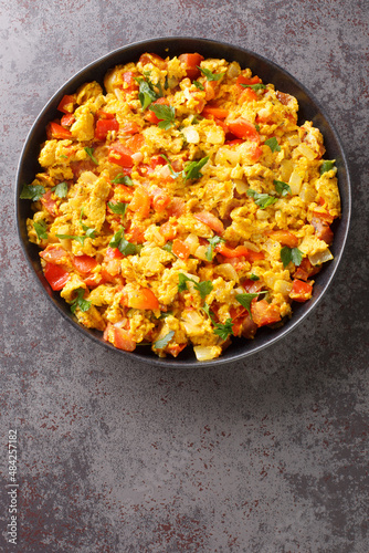 Anda Bhurji is an Indian Style Spicy Scrambled Eggs closeup in the plate on the table. Vertical top view from above