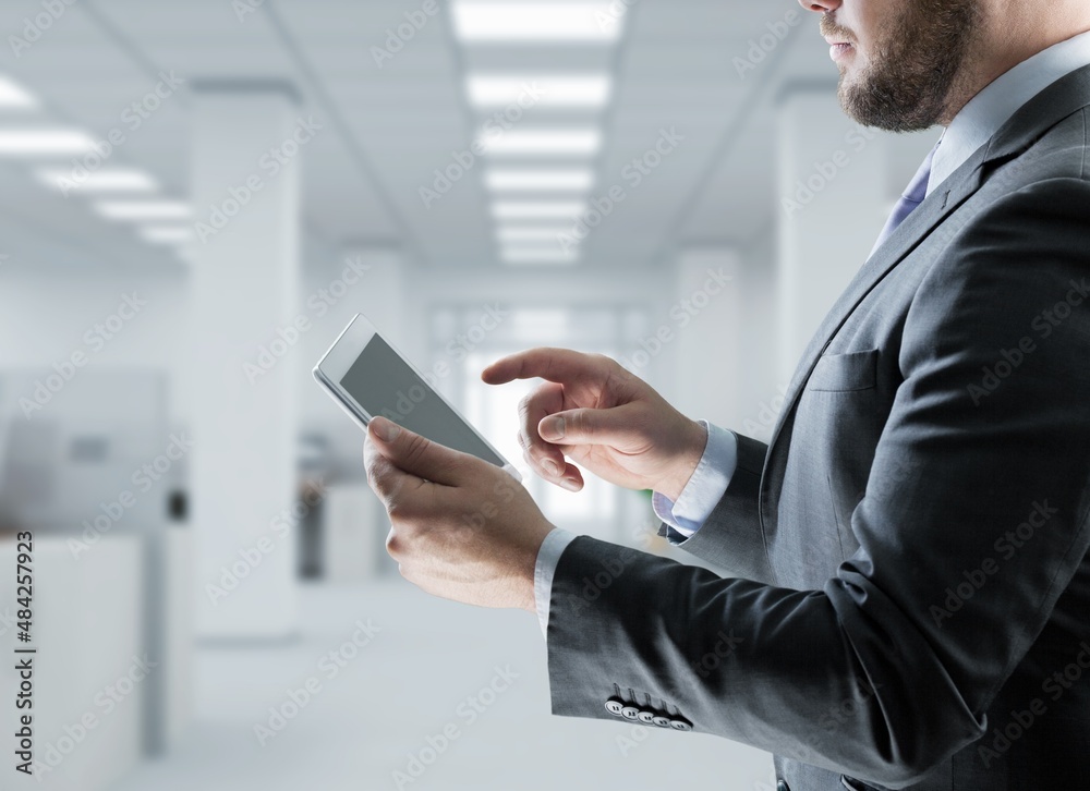 Young marketing business manager expert standing in modern corporate office using digital tablet Young marketing business manager expert standing in modern corporate office using digital tablet