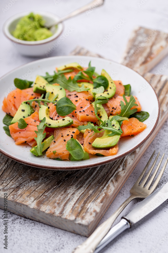 Fresh salmon salad with avocado, for keto and low carb diet. Rusty background, top view, copy space. Fresh salmon salad with avocado, for keto and low carb diet. Rusty background, top view, copy space.