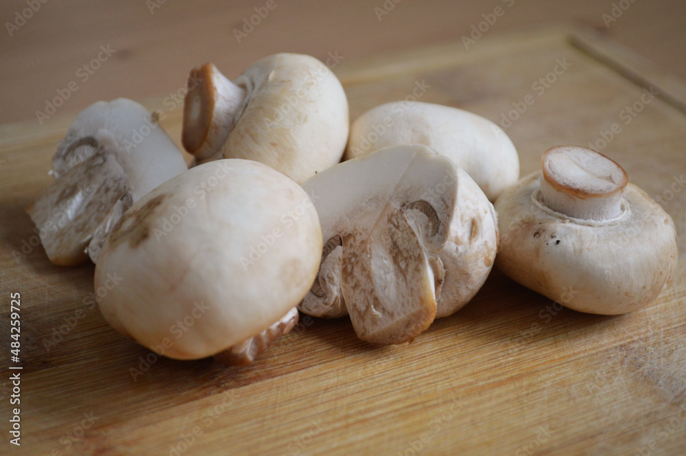 Close-up of white champignon mushrooms on cutting board
