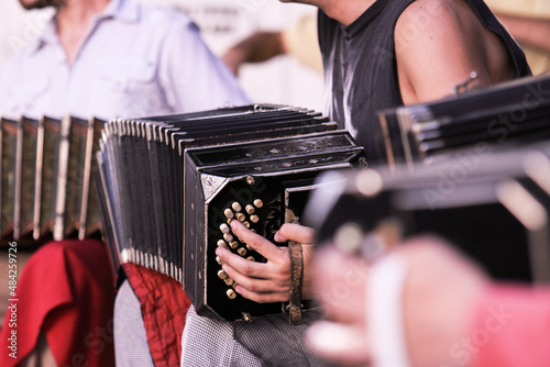 Close-up of Argentine bandoneon player performing on the street playing tango music with orchestra in Buenos Aires, Argentina.