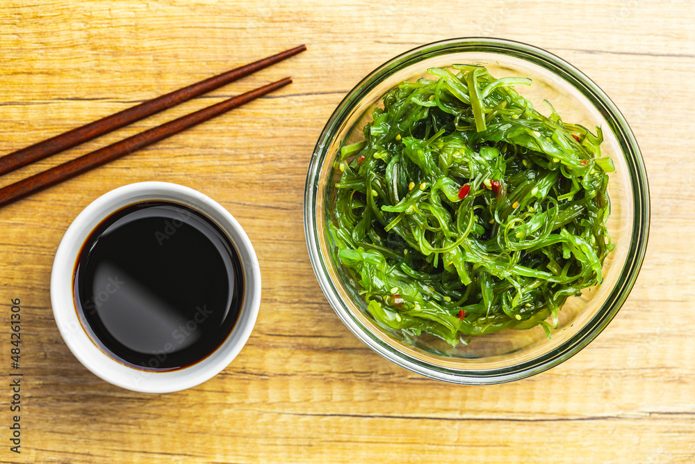 Green wakame. Seaweed salad and soy sauce in bowl. Green wakame. Seaweed salad and soy sauce in bowl.