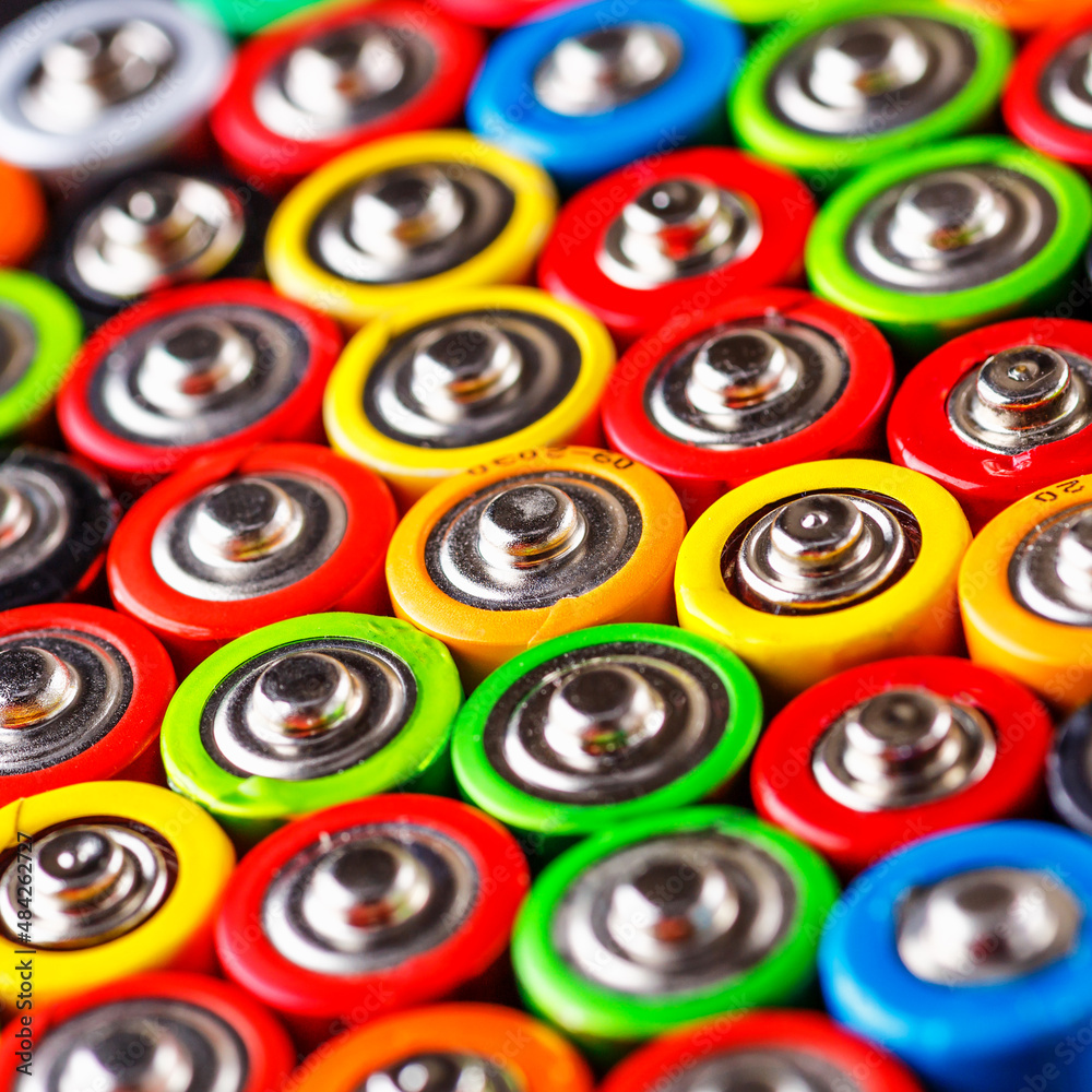 Fototapeta premium Energy abstract background of colorful batteries.Used batteries from different manufacturers, waste, collection and recycling,Alkaline battery aa size.Concept background of colorful batteries