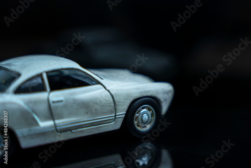 a model of an old classic shabby car on a glossy black glass background