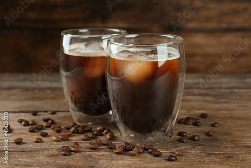 Glasses of delicious iced coffee served on wooden table