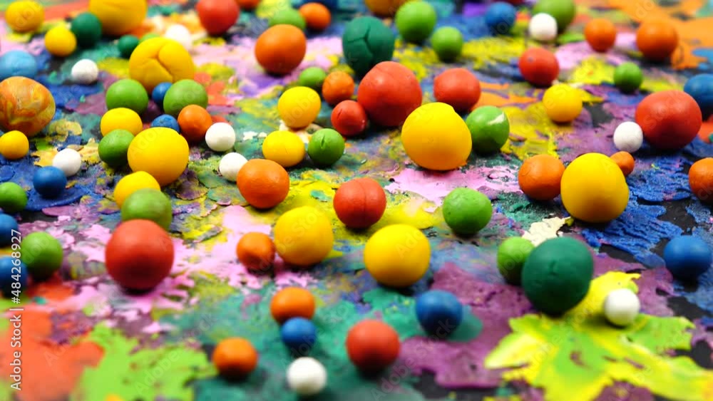 Multi colored plasticine balls and cardboard with plasticine abstract painting rotate on a photography turntable