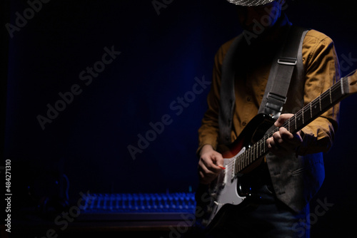 Man playing electric guitar. Musician in studio holding electric guitar