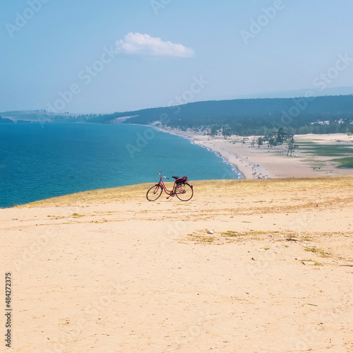 Bicycle on beach, sandy coast by sea. Concept of freedom, space, travel and tourism