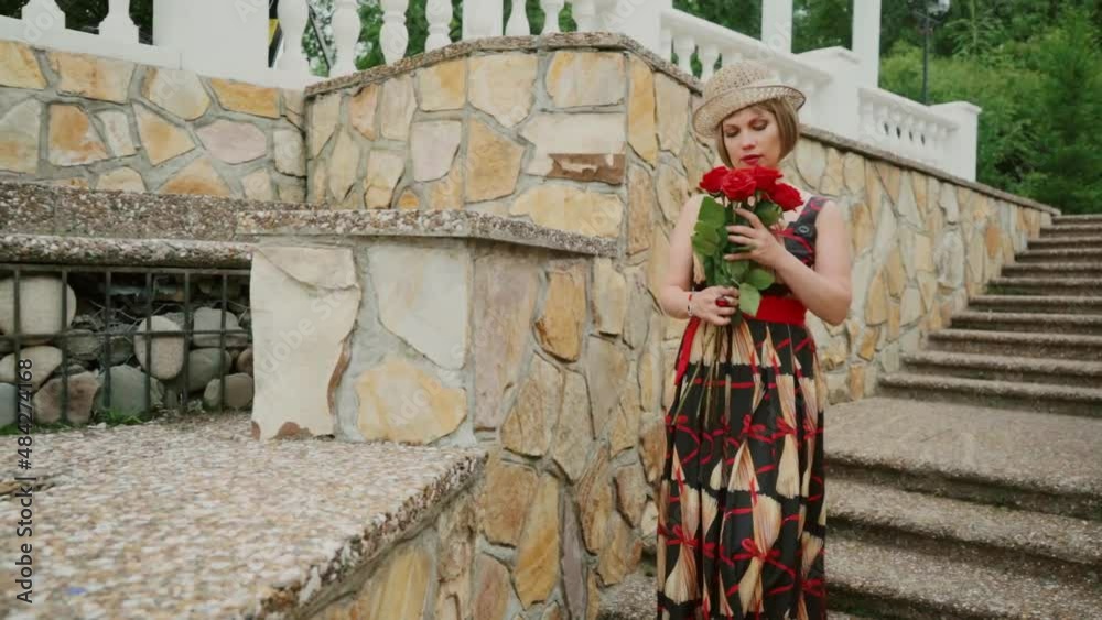 Retro girl with red roses. A girl with red roses, presented by a loved one, thinks about him and dreams of seeing him again. Retro girl with red roses. A girl with red roses, presented by a loved one, thinks about him and dreams of seeing him again.