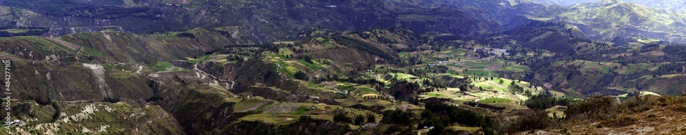 Panorama of mountains and green valley with traditional adobe buildings in mountains of Ecuador near Latacunga.