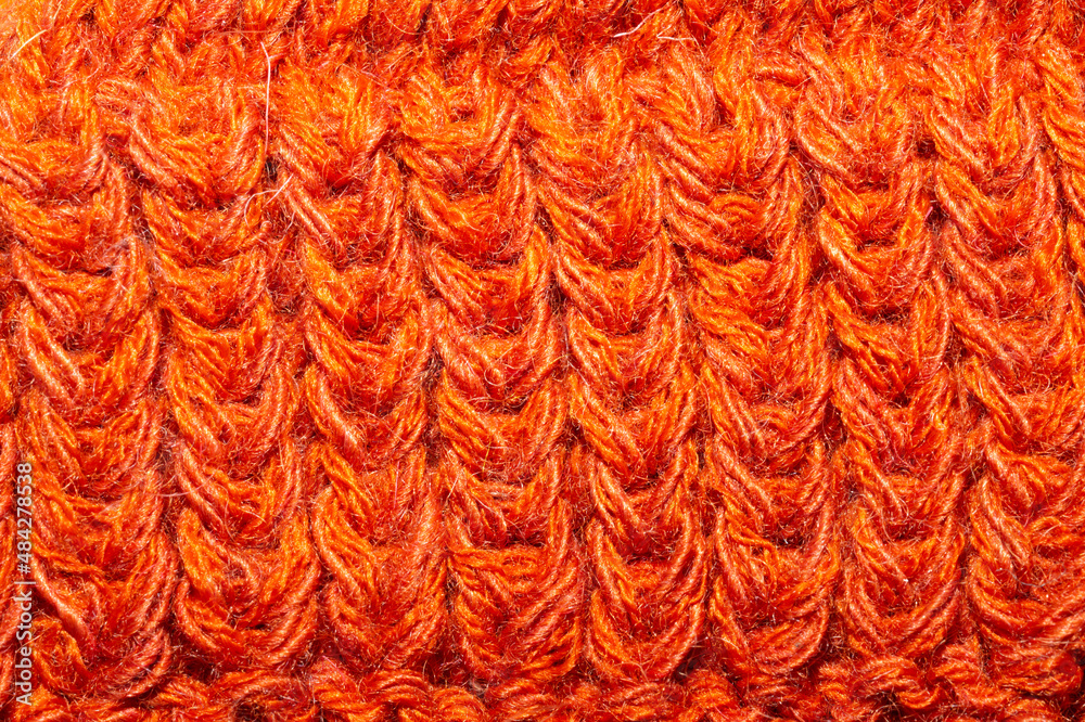 Knitted background close up. orange woolen fabric