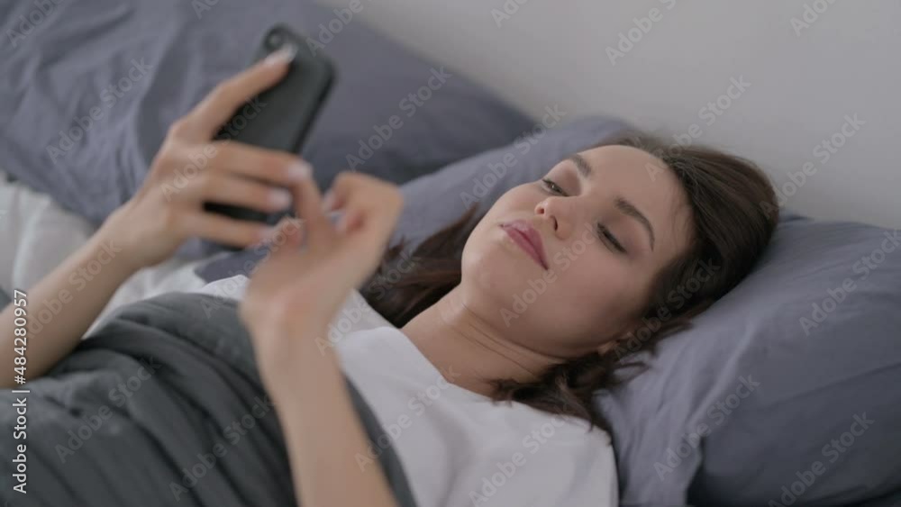 Woman using Smartphone while Sleeping in Bed Woman using Smartphone while Sleeping in Bed