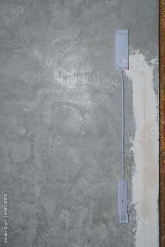 Intercom phone receiver on gray concrete background. handset hanging on the wire