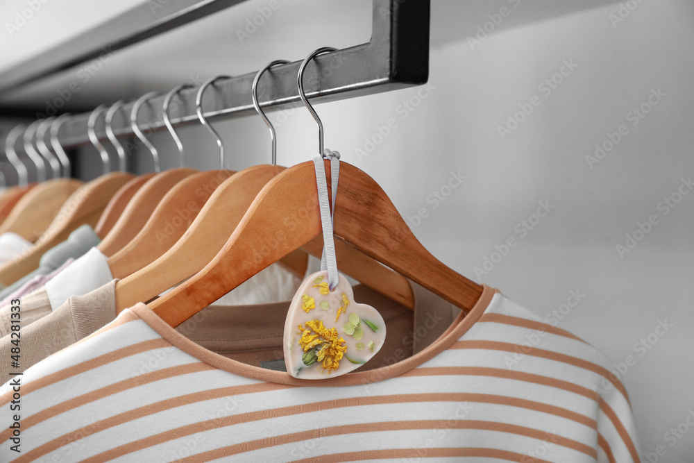 Beautiful scented sachet and clothes hanging in wardrobe