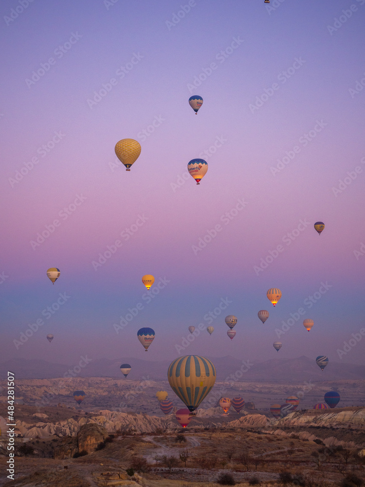 Obraz premium Bright multi-colored hot air balloons flying in sunsrise sky Cappadocia Turkey.