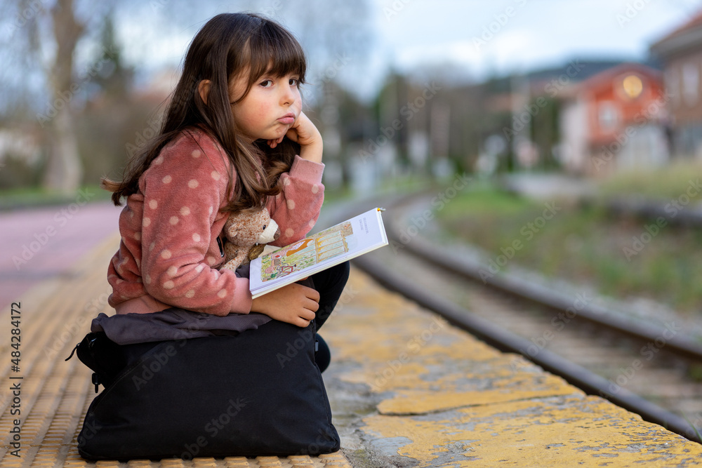 Fototapeta premium Bored girl waits for the arrival of the train