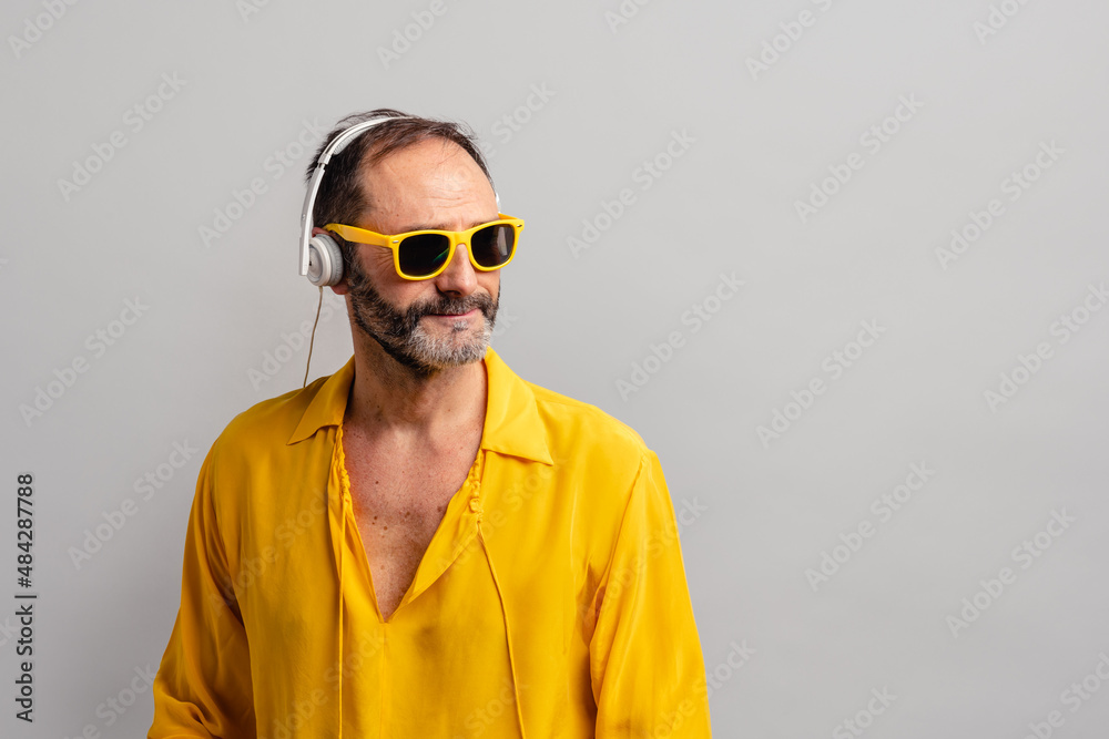 Stylish senior man enjoying music on earphones with sunglasses Stylish senior man enjoying music on earphones with sunglasses