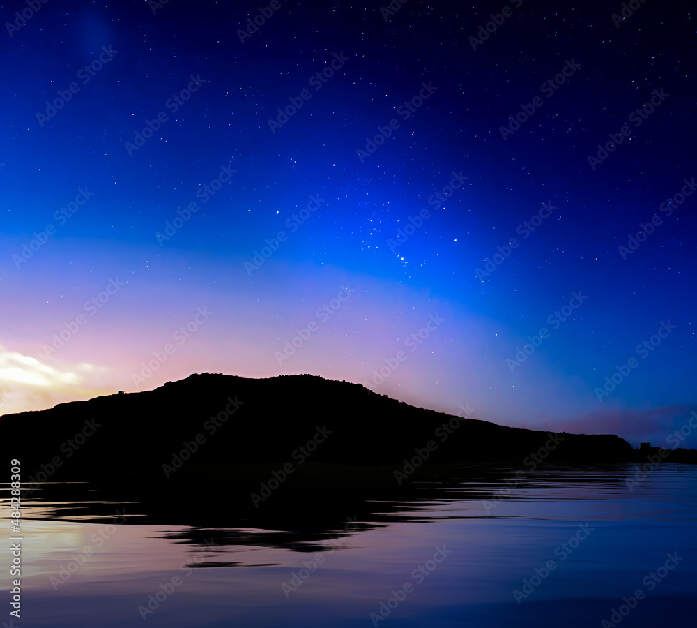 Fototapeta premium Starry Skies over Coastline Silhouette
