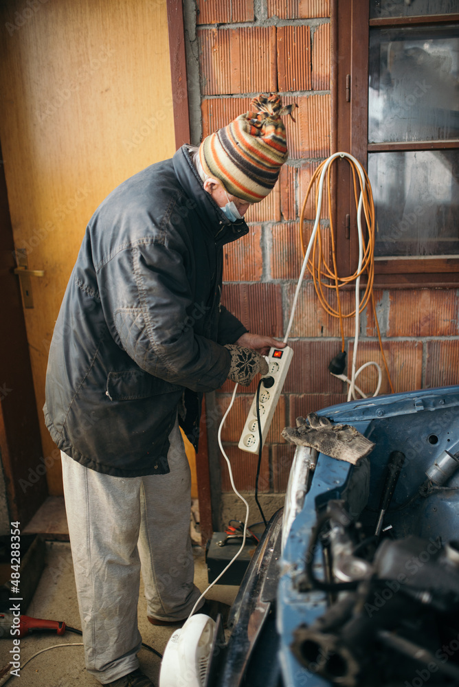 Senior man turns on the electricity in the garage. Senior man turns on the electricity in the garage.