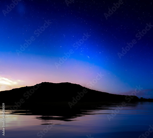 Starry Skies over Coastline Silhouette