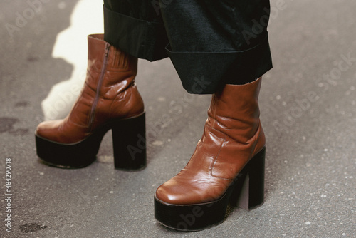 woman wearing brown leather platform shoes and black leather skirt
