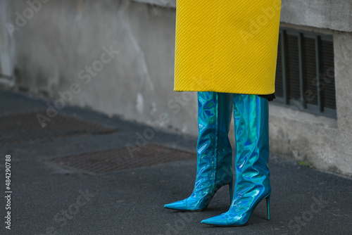 woman wearing neon blue high heel boots and yellow coat