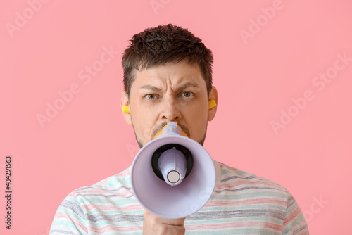 Angry young man with ear pl...
