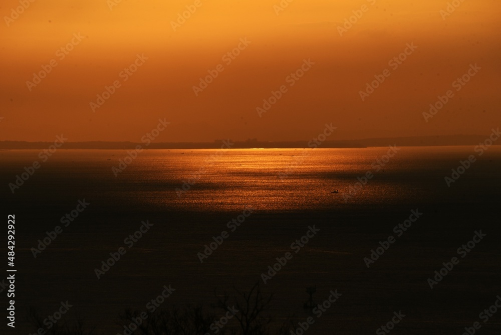 The sight of the sunrise, the silhouette of the sunrise and the brilliance of the sea surface. 