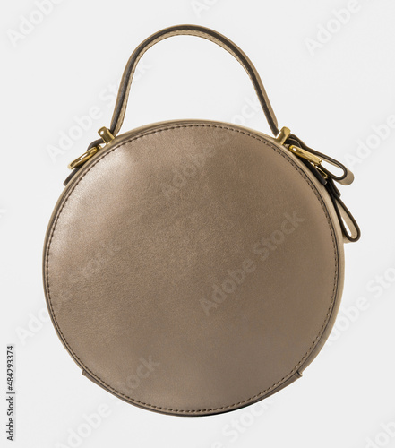 Round-shaped leather handbag in gold color. Model with one handle