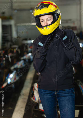 Nice woman in helmet standing near sport cars for karting in sport club © JackF