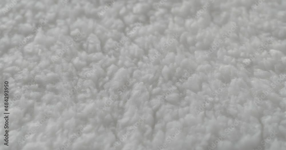 White fleece close-up. Macro shooting of soft and warm fabric. Woolen clothing, abstract background. Tailoring and sewing concept. Material sample. White fleece close-up. Macro shooting of soft and warm fabric. Woolen clothing, abstract background. Tailoring and sewing concept. Material sample.