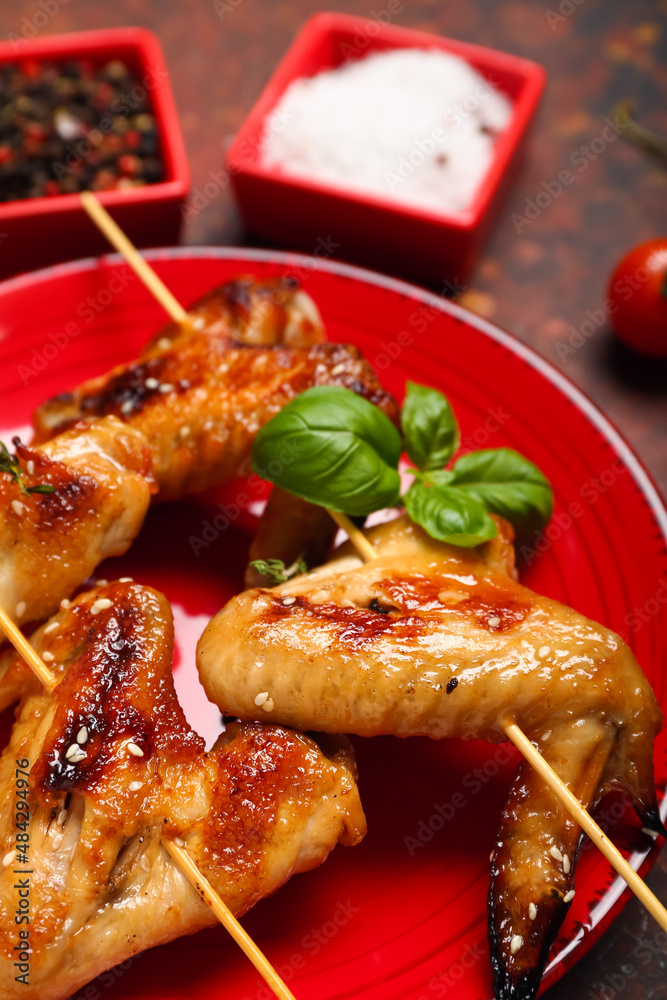 Plate with grilled chicken wings skewers on table Plate with grilled chicken wings skewers on table