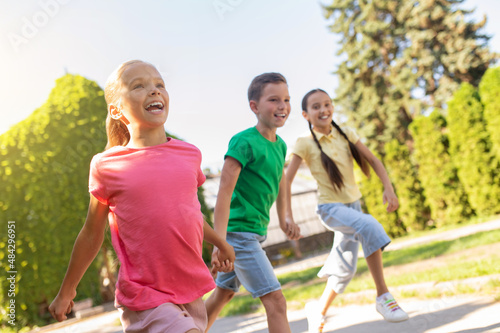 Boy and two girls running hand in hand