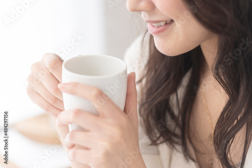 朝、温かい飲み物を飲む女性