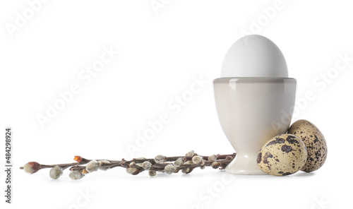 Different Easter eggs and willow branches on white background