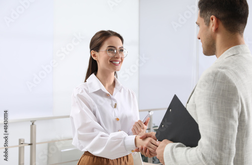 Employee shaking hands with intern in office