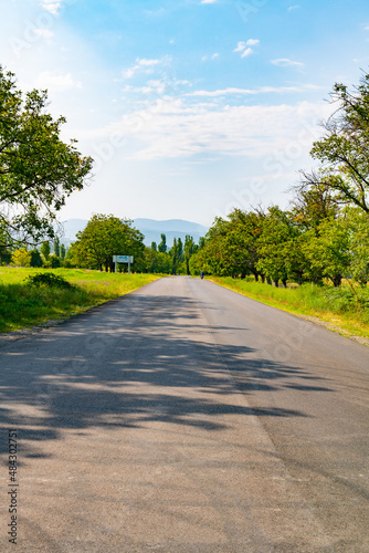 a very narrow asphalt road towards the mountains goes